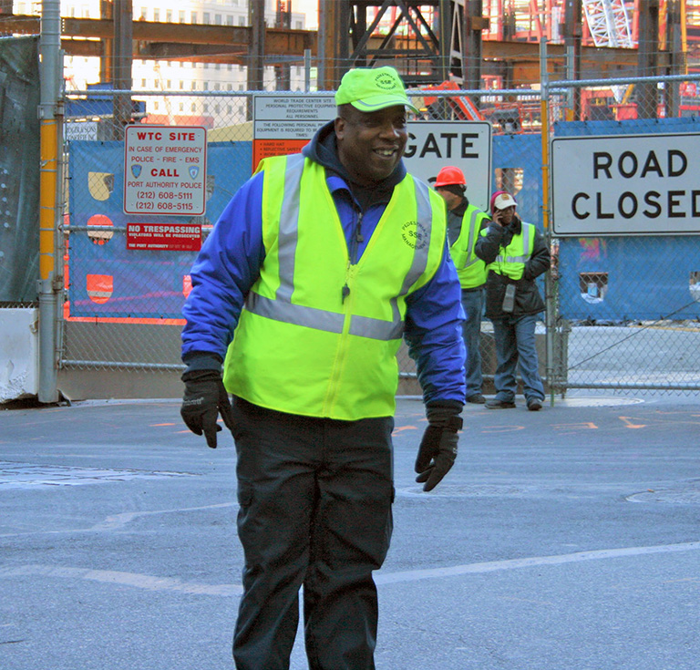 smiling safety personnel worker in front of construction site